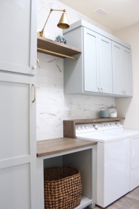 laundry room-diy-cabinets-painted-blue-marble-wall-tile-gold-sconce-light-rustic-shelves-above-washer-dryer